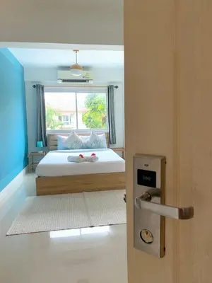 a bedroom with a large bed with a window at Turtle Rooms in Bang Tao Beach