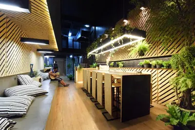a man sitting on a couch in a room with a bar at Hugger Hostel in Phuket Town