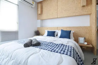 a bedroom with a large bed with blue pillows at Hugger Hostel in Phuket Town