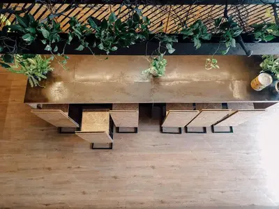 a table with benches and potted plants on it at Hugger Hostel in Phuket Town