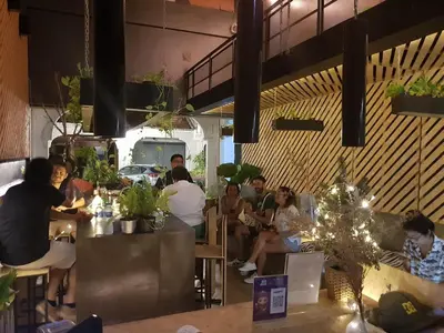 a group of people sitting in a restaurant at Hugger Hostel in Phuket Town
