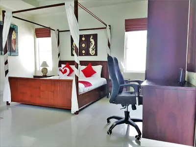 a bedroom with a bed and a desk and a chair at Prima Villas Karon Beach by PHR in Karon Beach
