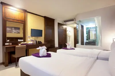 a hotel room with two beds and a desk at Supicha Pool Access Hotel - SHA Plus in Phuket Town