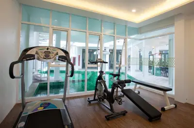 a room with a gym with a treadmill and a swimming pool at Supicha Pool Access Hotel - SHA Plus in Phuket Town