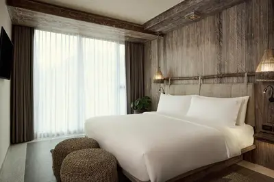 a bedroom with a large white bed and a window at Dinso Resort & Villas Phuket, Vignette Collection by IHG in Patong Beach