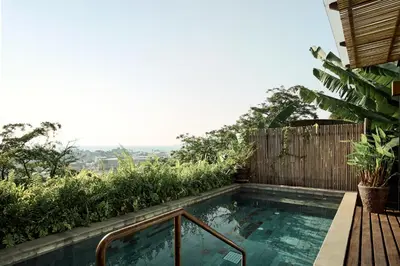 a small swimming pool next to a wooden fence at Dinso Resort & Villas Phuket, Vignette Collection by IHG in Patong Beach