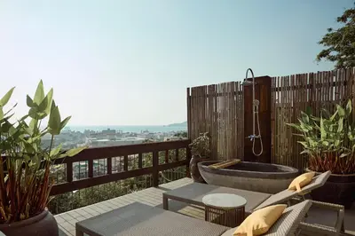 a balcony with a bath tub on a deck at Dinso Resort & Villas Phuket, Vignette Collection by IHG in Patong Beach