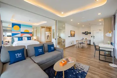 a living room with a couch and a bed in a room at NH Boat Lagoon Phuket Resort in Phuket Town