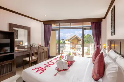 a bedroom with a large bed with red roses on it at Club Bamboo Boutique Patong Beach Resort in Patong Beach