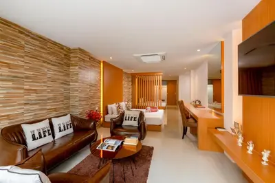 a living room with a couch and a table at Club Bamboo Boutique Patong Beach Resort in Patong Beach