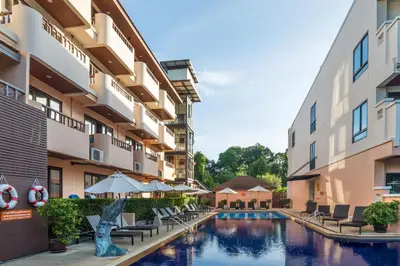 a hotel courtyard with a pool with chairs and umbrellas at Srisuksant Resort in Ao Nang Beach