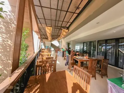 a restaurant with wooden tables and chairs and windows at Phu Dahla Residences in Ao Nang Beach