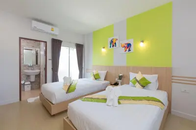 a hotel room with two beds and a bathroom at Phant at Thalang Service Apartment in Thalang