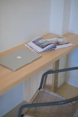 a desk with a laptop and a magazine on it at Phant at Thalang Service Apartment in Thalang