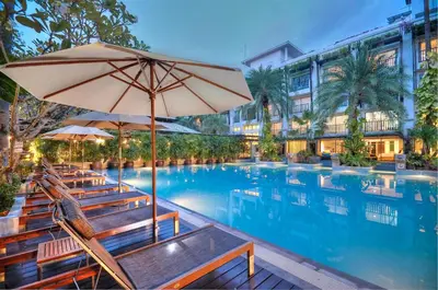 a pool with chairs and an umbrella and a hotel at Burasari Phuket Resort & Spa in Patong Beach