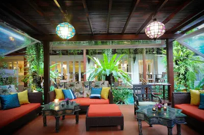 a living room with red couches and tables at Burasari Phuket Resort & Spa in Patong Beach
