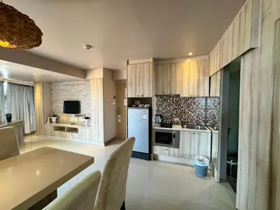 a kitchen with wooden cabinets and a white refrigerator at Condo Minium Patong Phuket in Patong Beach