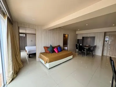 a hotel room with a bed and a dining room at Condo Minium Patong Phuket in Patong Beach