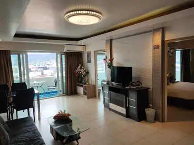 a living room with a couch and a television in a room at Condo Minium Patong Phuket in Patong Beach