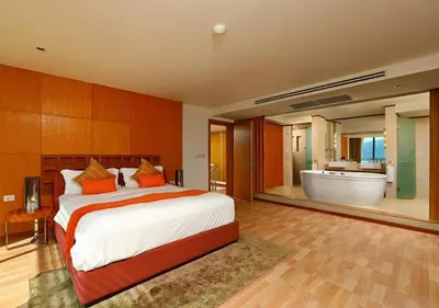 a bedroom with a large bed and a bath tub at IndoChine Resort and Villas in Patong Beach