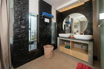 a bathroom with two sinks and a mirror at IndoChine Resort and Villas in Patong Beach