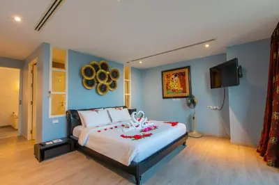 a bedroom with a large bed with red flowers on it at IndoChine Resort and Villas in Patong Beach