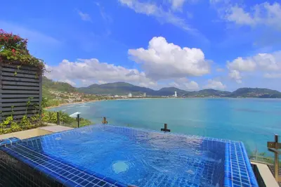 a swimming pool with a view of the ocean at IndoChine Resort and Villas in Patong Beach