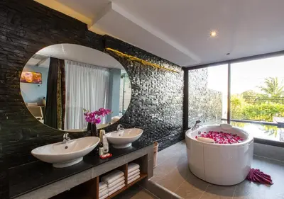 a bathroom with two sinks and a tub and a mirror at IndoChine Resort and Villas in Patong Beach