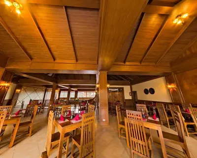 an empty restaurant with wooden tables and chairs at Andamanee Boutique Resort Aonang Krabi - Free Beach Shuttle in Ao Nang Beach