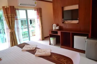 a bedroom with a bed with a tv and a window at Aonang Village Resort in Ao Nang Beach