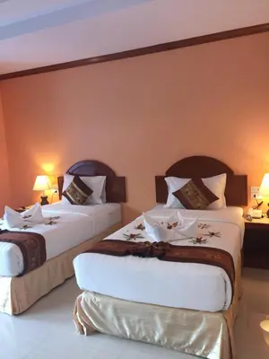 two beds in a hotel room with two lamps at Aonang Village Resort in Ao Nang Beach