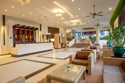a lobby of a hotel with tables and chairs at Deevana Patong Resort & Spa in Patong Beach