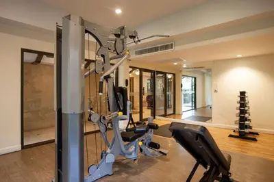 a gym with treadmills and ellipticals in a room at Deevana Patong Resort & Spa in Patong Beach