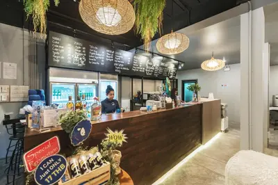 a woman standing behind a bar in a restaurant at Kokotel Krabi Oasis in Ao Nang Beach