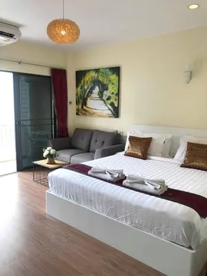 a large white bed in a room with a couch at DB Residence in Patong Beach