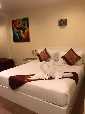 a white bed with two white towels on it at DB Residence in Patong Beach