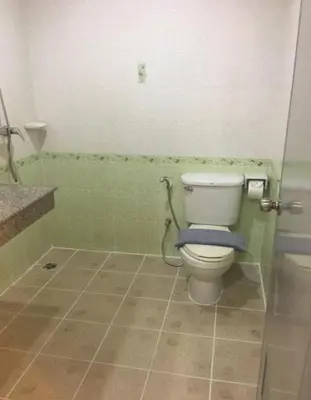 a bathroom with a toilet with a blue towel on it at DB Residence in Patong Beach