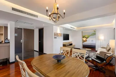a dining room and living room with a table and chairs at DoubleTree by Hilton Phuket Banthai Resort in Patong Beach
