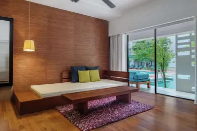 a bedroom with a bed with a wooden wall at DoubleTree by Hilton Phuket Banthai Resort in Patong Beach