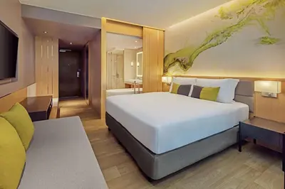 a bedroom with a large white bed and a bathroom at DoubleTree by Hilton Phuket Banthai Resort in Patong Beach