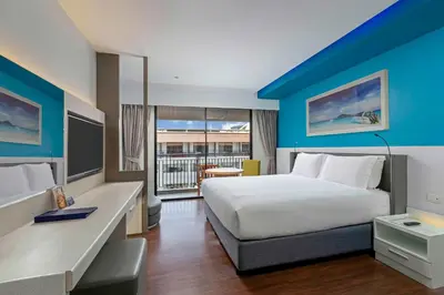 a hotel room with a large bed and a desk at DoubleTree by Hilton Phuket Banthai Resort in Patong Beach