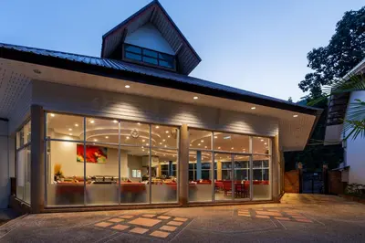 a house with large glass windows and a building at Ao Nang Timber House in Ao Nang Beach