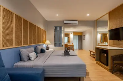 a bedroom with a large bed and a kitchen at Ao Nang Timber House in Ao Nang Beach