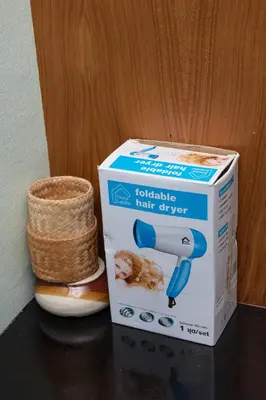 a box of a hair dryer next to a basket at Hotel Sole in Patong Beach