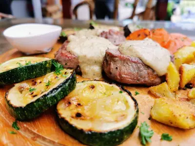 a plate of food with meat and vegetables on a table at Hotel Sole in Patong Beach