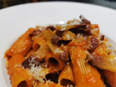 a white plate of pasta with cheese and sauce at Hotel Sole in Patong Beach