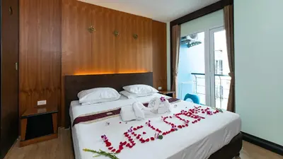 a hotel room with a bed with flowers on it at Hotel Sole in Patong Beach