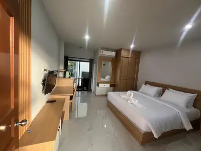 a bedroom with a bed and a television in it at J2 Airport Mansion in Nai Yang Beach