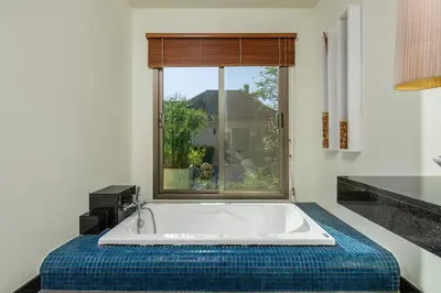 a bath tub in a room with a window at Villa Adonara Private Pool Escape Near Nai Harn in Nai Harn Beach