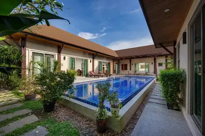 a house with a swimming pool in front of it at Villa Adonara Private Pool Escape Near Nai Harn in Nai Harn Beach